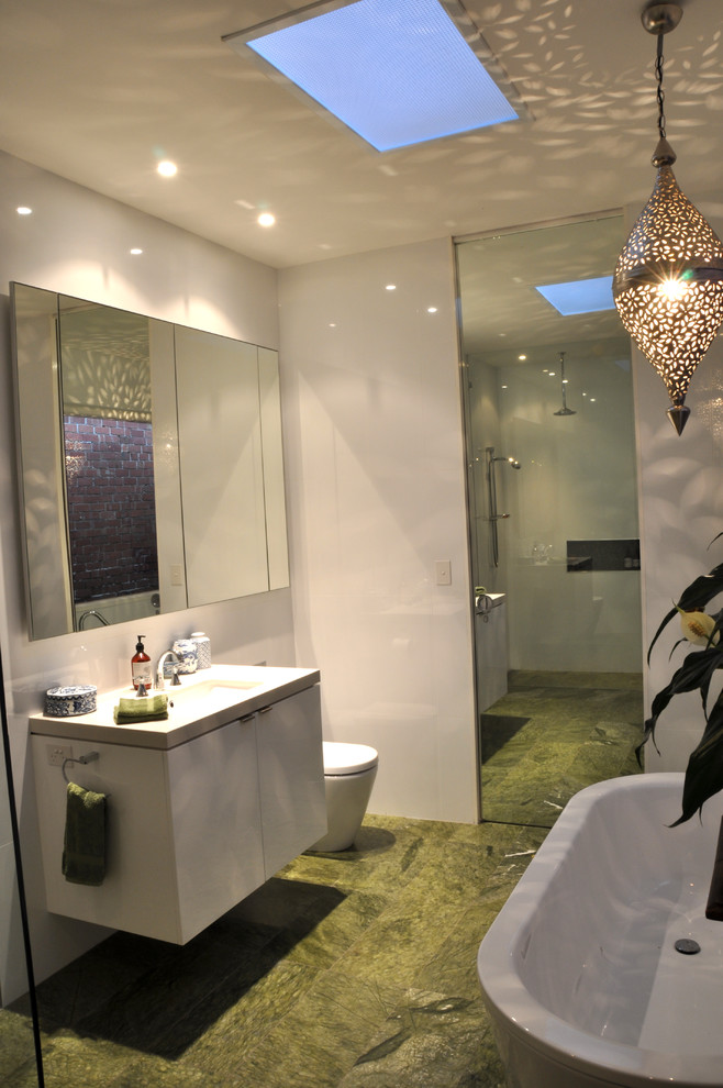Design ideas for a modern master bathroom in Geelong with flat-panel cabinets, white cabinets, a freestanding tub, a corner shower, a one-piece toilet, white tile, porcelain tile, white walls, marble floors, an undermount sink, green floor and an open shower.