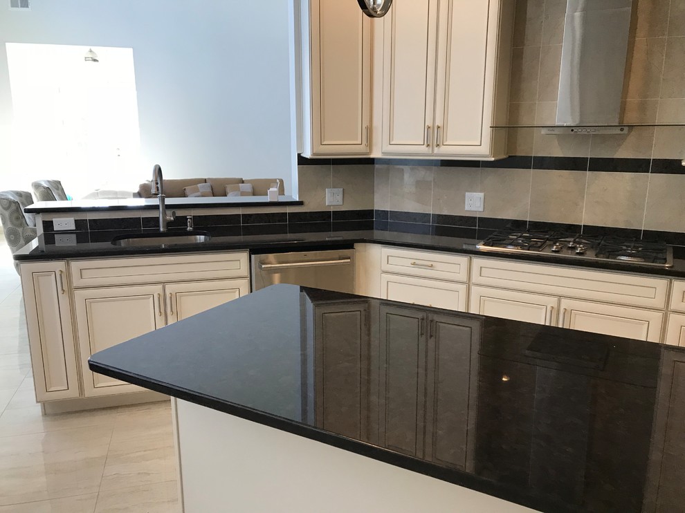 Mid-sized transitional u-shaped separate kitchen in Philadelphia with an undermount sink, raised-panel cabinets, beige cabinets, granite benchtops, multi-coloured splashback, porcelain splashback, stainless steel appliances, porcelain floors, with island, beige floor and black benchtop.