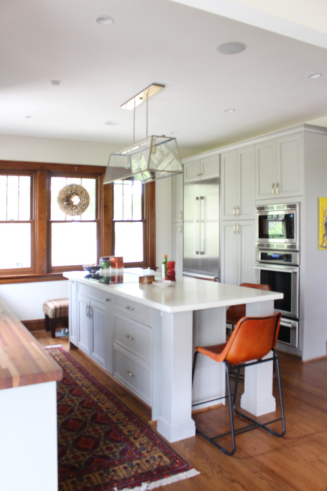 Mid-sized transitional dark wood floor kitchen photo in Cincinnati with a drop-in sink, gray cabinets, concrete countertops, white backsplash, stainless steel appliances and an island