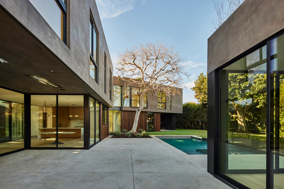 Свежая идея для дизайна: огромный двор на заднем дворе в стиле модернизм с мощением тротуарной плиткой и навесом - отличное фото интерьера