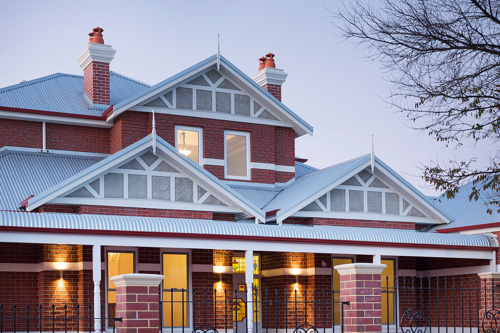 Large contemporary two-storey brick red house exterior in Perth with a hip roof and a metal roof.