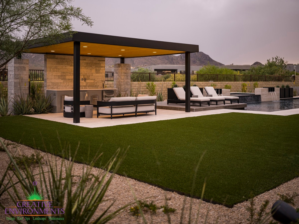 Inspiration for a large modern back formal partial sun pergola for summer in Phoenix with concrete paving and a metal fence.