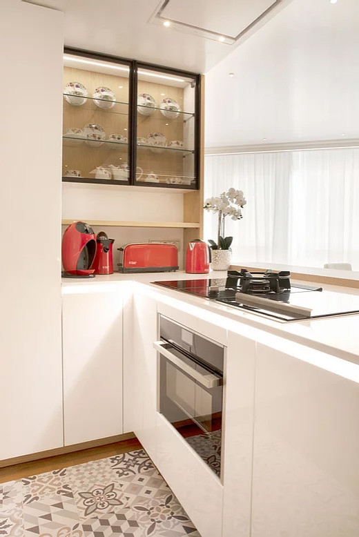 Foto di una cucina scandinava di medie dimensioni con lavello integrato, top in quarzo composito, elettrodomestici da incasso, pavimento in legno massello medio, penisola, pavimento marrone e top bianco