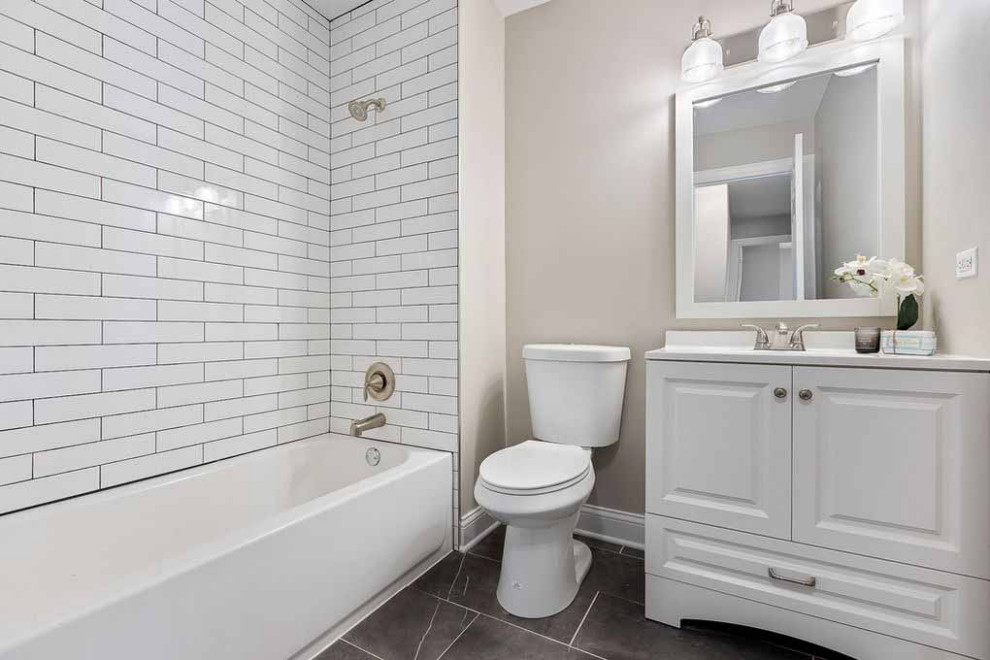 Modern inredning av ett mellanstort grå grått badrum med dusch, med släta luckor, skåp i mellenmörkt trä, ett fristående badkar, en dusch i en alkov, en toalettstol med hel cisternkåpa, vit kakel, keramikplattor, vita väggar, klinkergolv i keramik, ett undermonterad handfat, bänkskiva i kvartsit, gult golv och dusch med skjutdörr