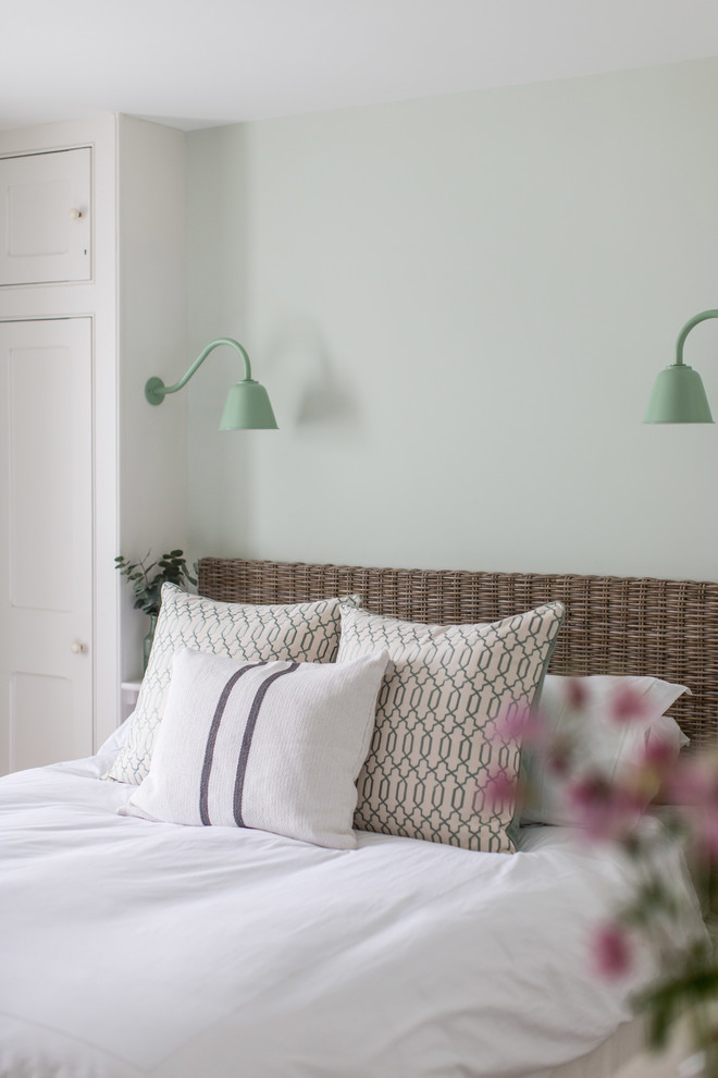 Design ideas for a beach style guest bedroom in London with green walls.