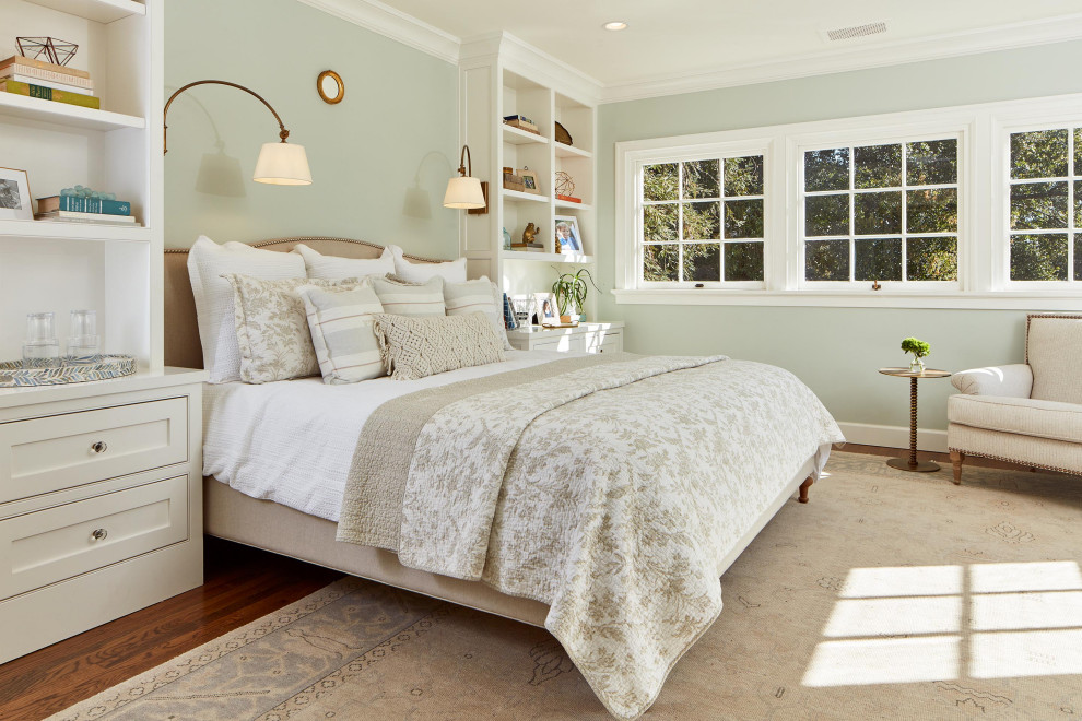 Large traditional master bedroom in San Francisco with green walls, medium hardwood floors and brown floor.