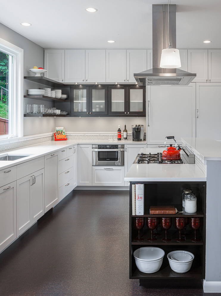 Mid-sized transitional l-shaped kitchen in Seattle with an undermount sink, shaker cabinets, white cabinets, stainless steel appliances, cork floors and with island.