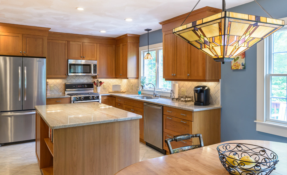 Large arts and crafts l-shaped eat-in kitchen in Boston with shaker cabinets, beige splashback, subway tile splashback, stainless steel appliances, with island, an undermount sink, medium wood cabinets, granite benchtops, marble floors and white floor.