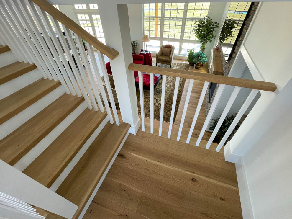 This is an example of a mid-sized country wood u-shaped staircase in DC Metro with wood risers, wood railing and planked wall panelling.