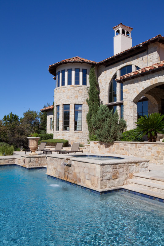 Photo of a large mediterranean backyard custom-shaped natural pool in Austin with natural stone pavers.