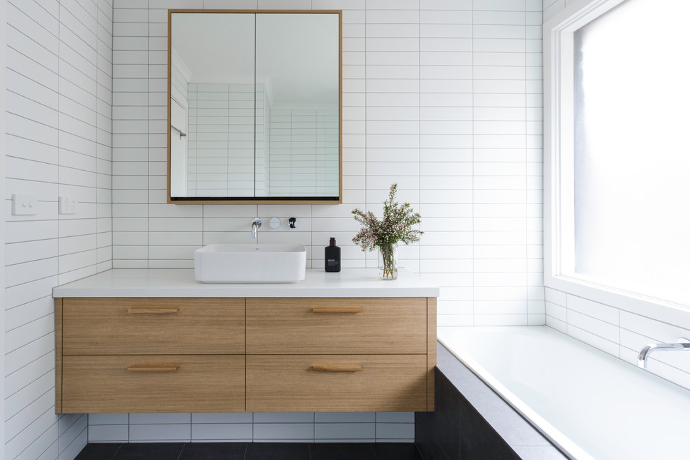 Mid-sized contemporary 3/4 bathroom in Melbourne with beaded inset cabinets, light wood cabinets, a corner tub, an open shower, white tile, subway tile, a drop-in sink, solid surface benchtops, an open shower and white benchtops.