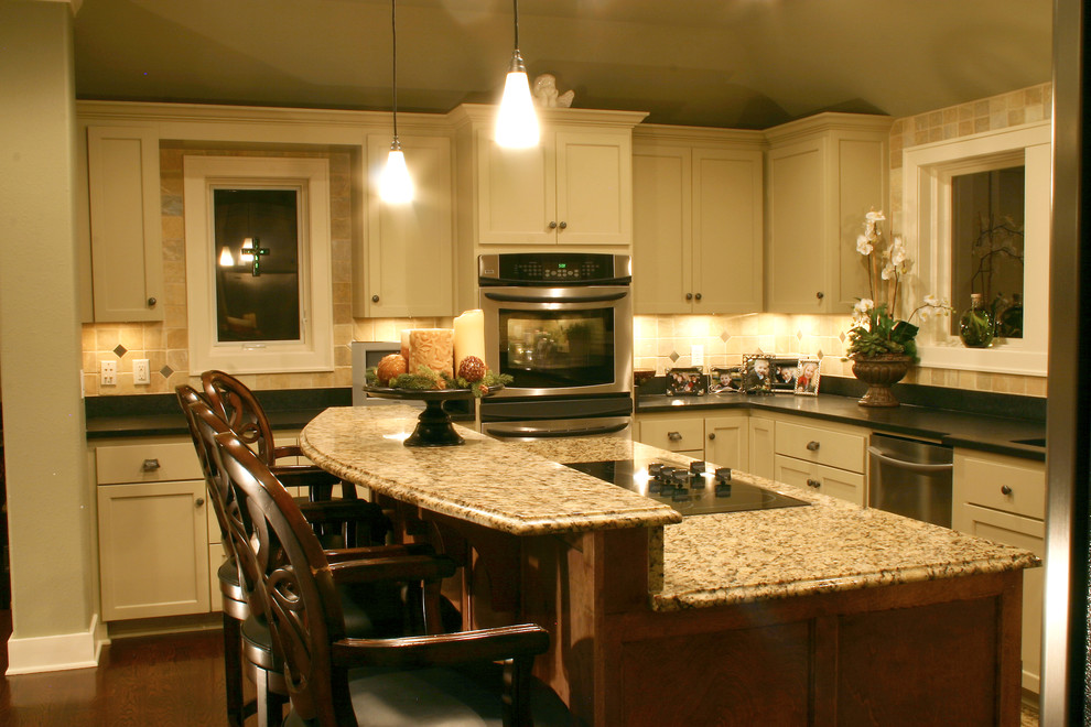 This is an example of a large traditional u-shaped eat-in kitchen in Milwaukee with a single-bowl sink, recessed-panel cabinets, white cabinets, granite benchtops, beige splashback, stainless steel appliances, medium hardwood floors, with island and stone tile splashback.