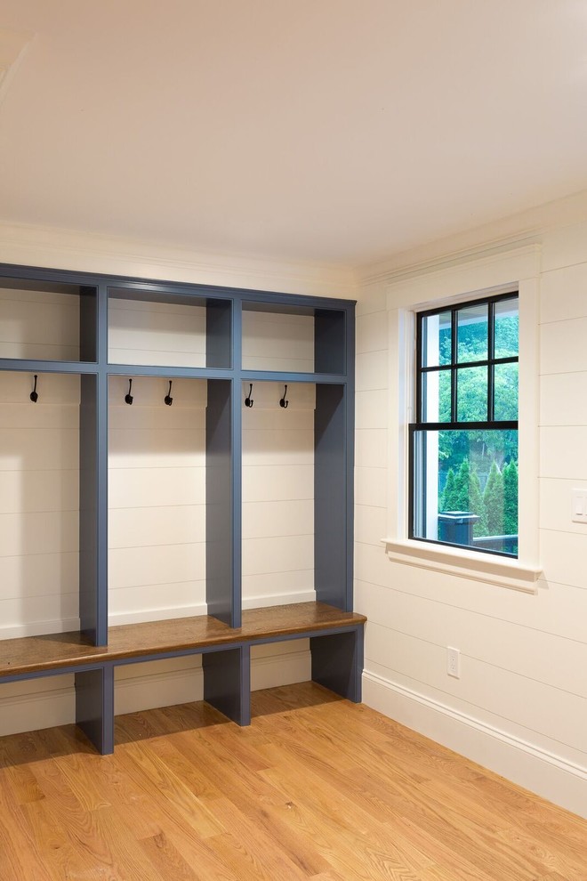 Design ideas for a mid-sized traditional mudroom in Boston with white walls, medium hardwood floors and brown floor.