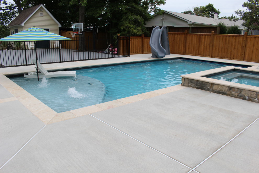 Photo of a mid-sized traditional front yard rectangular natural pool in DC Metro with a water slide and decking.