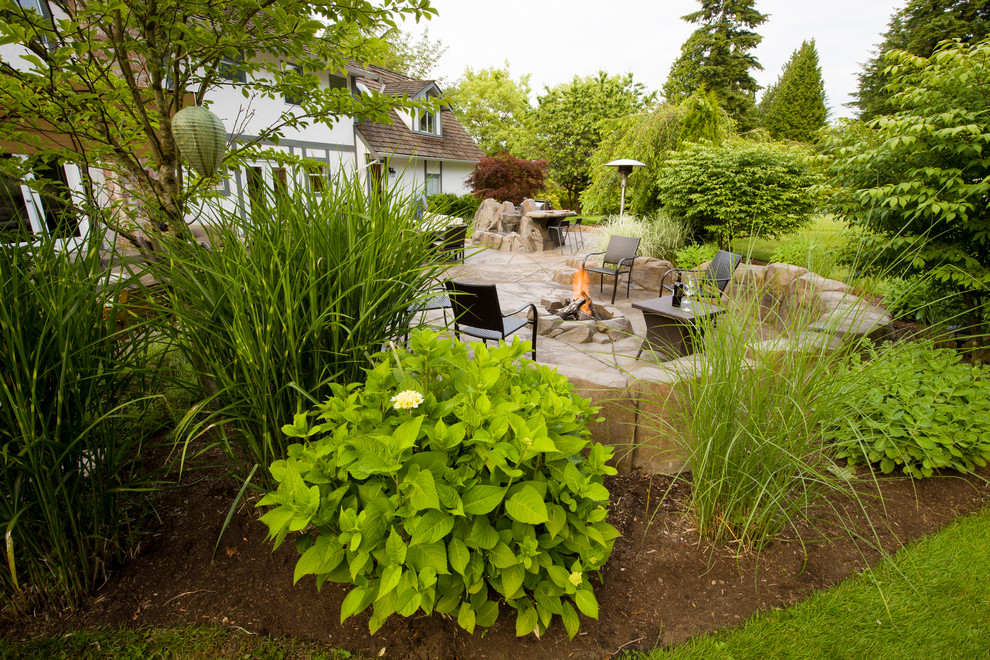 This is an example of a mid-sized arts and crafts backyard patio in Vancouver with a fire feature and stamped concrete.