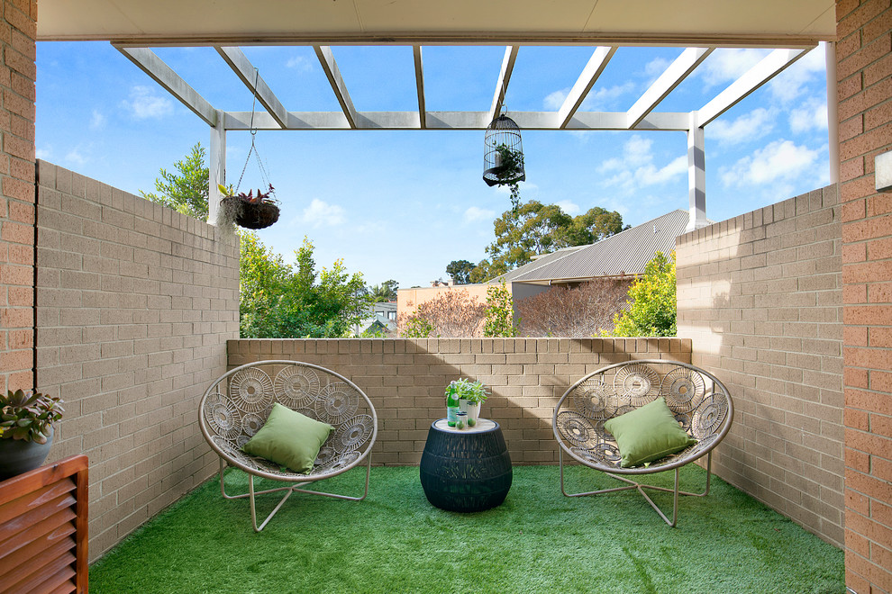 Mid-sized modern balcony in Sydney with a pergola and with privacy feature.