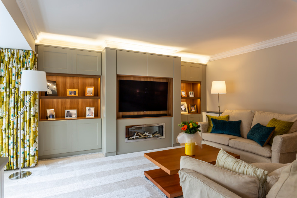 Large modern enclosed living room in Hertfordshire with a music area, grey walls, carpet, a hanging fireplace, a wood fireplace surround, a built-in media wall and beige floor.