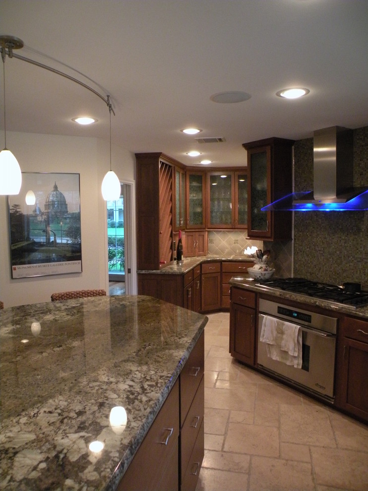 Inspiration for a mid-sized transitional u-shaped limestone floor eat-in kitchen remodel in Houston with an undermount sink, shaker cabinets, medium tone wood cabinets, granite countertops, beige backsplash, ceramic backsplash, stainless steel appliances and an island