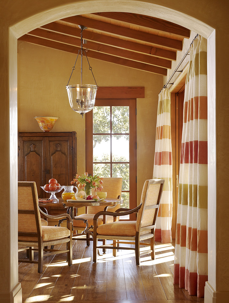 Inspiration for a mediterranean dining room in San Francisco with beige walls and medium hardwood floors.