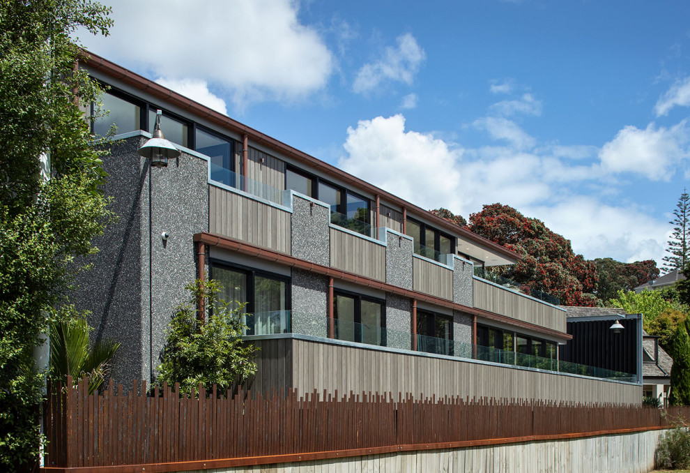 Photo of an expansive industrial three-storey concrete house exterior in Auckland.