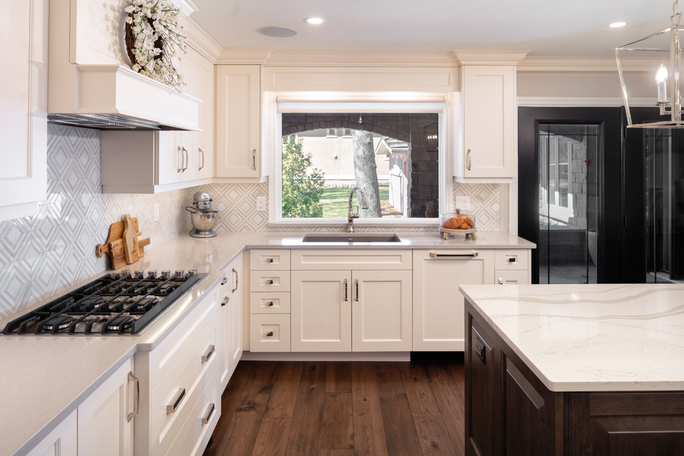 Kitchen pantry - transitional u-shaped kitchen pantry idea with an undermount sink, shaker cabinets, white cabinets, quartz countertops, beige backsplash, an island and beige countertops