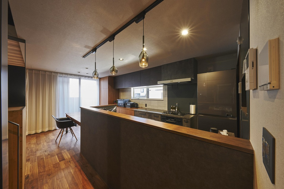На фото: большая прямая кухня в стиле модернизм с мраморной столешницей, серым фартуком, черной техникой, темным паркетным полом, коричневым полом, коричневой столешницей, потолком с обоями и обоями на стенах