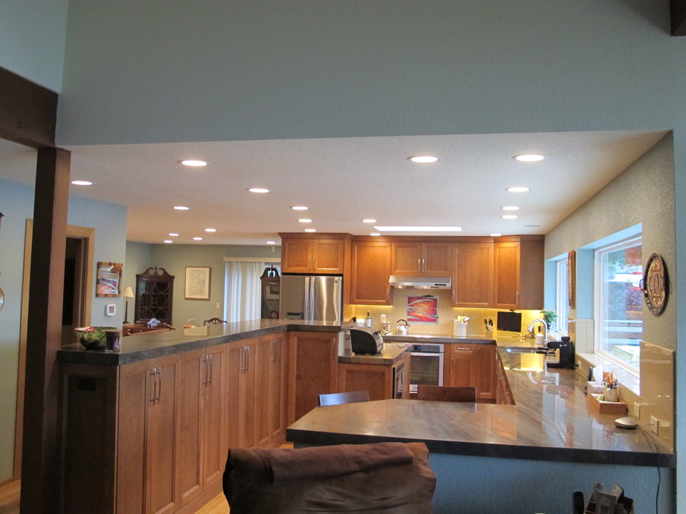 Large arts and crafts l-shaped medium tone wood floor open concept kitchen photo in Seattle with an undermount sink, recessed-panel cabinets, medium tone wood cabinets, granite countertops, beige backsplash, ceramic backsplash, stainless steel appliances and an island