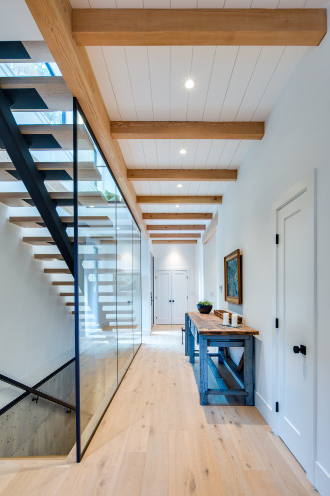 Mid-sized modern hallway in Vancouver with white walls, light hardwood floors and beige floor.