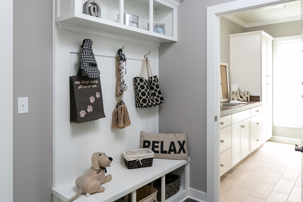 This is an example of a mid-sized arts and crafts laundry room in Other with a drop-in sink, shaker cabinets, white cabinets, wood benchtops, grey walls, porcelain floors and beige floor.