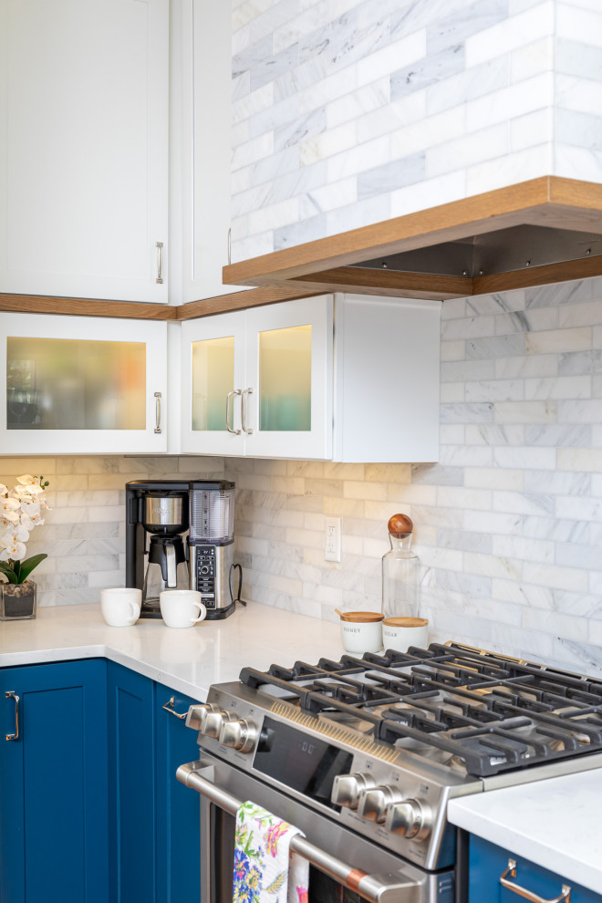Inspiration for a mid-sized transitional l-shaped medium tone wood floor and brown floor eat-in kitchen remodel in Raleigh with an undermount sink, shaker cabinets, blue cabinets, quartzite countertops, white backsplash, marble backsplash, stainless steel appliances, an island and white countertops
