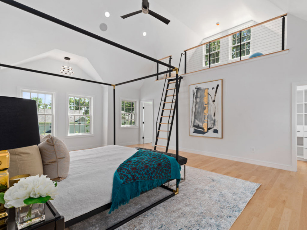 Large modern loft-style bedroom in Boston with light hardwood floors and brown floor.