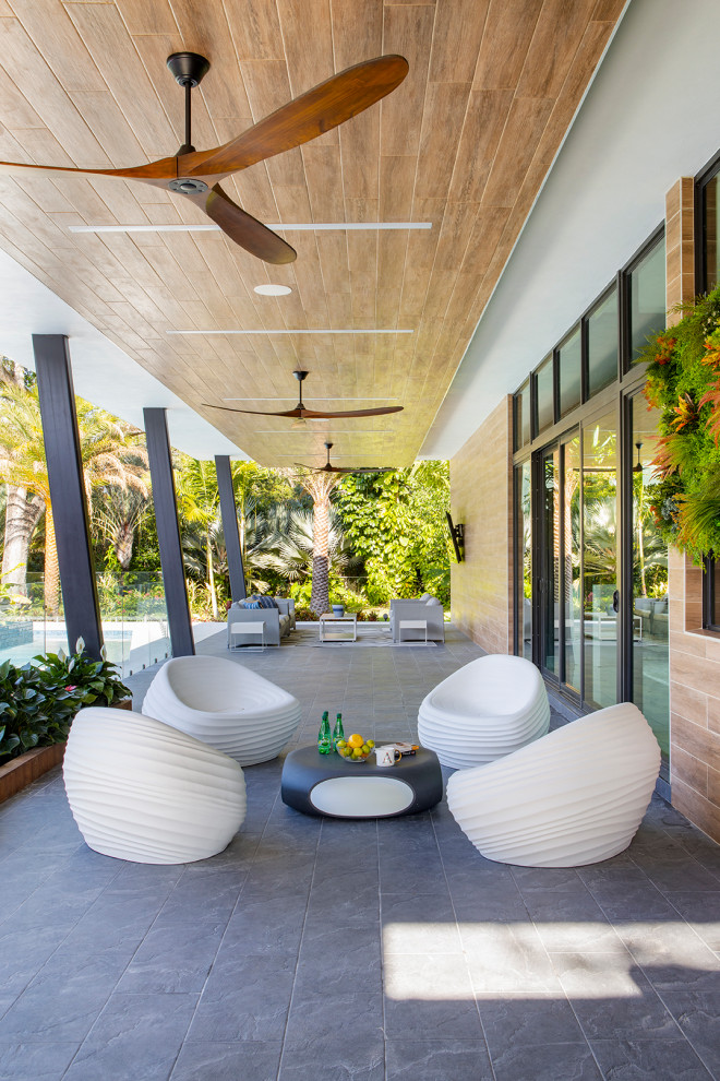 Large trendy wood white porch idea in Miami with a metal roof