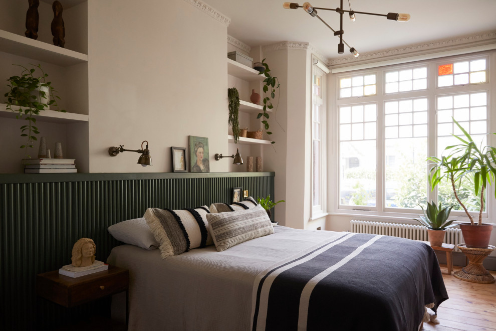 Ispirazione per una camera da letto boho chic con pareti beige, parquet chiaro e pavimento beige