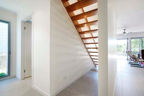 Inspiration for a mid-sized transitional wood straight staircase in Brisbane with wood risers and wood railing.
