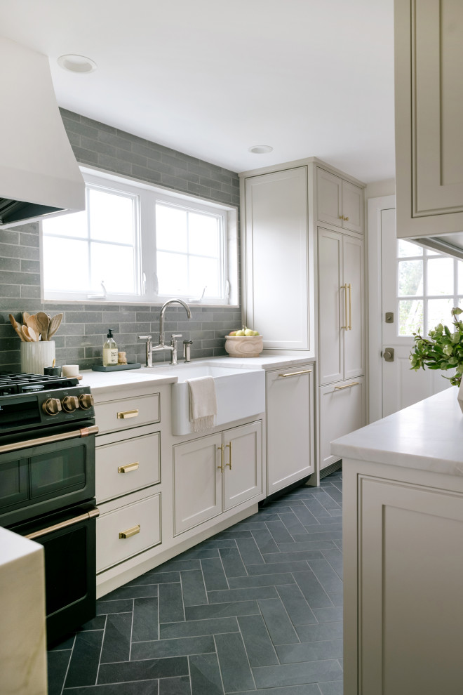 Inspiration for a small traditional l-shaped eat-in kitchen in Seattle with a farmhouse sink, beaded inset cabinets, grey cabinets, quartz benchtops, green splashback, ceramic splashback, black appliances, porcelain floors, a peninsula, grey floor and white benchtop.