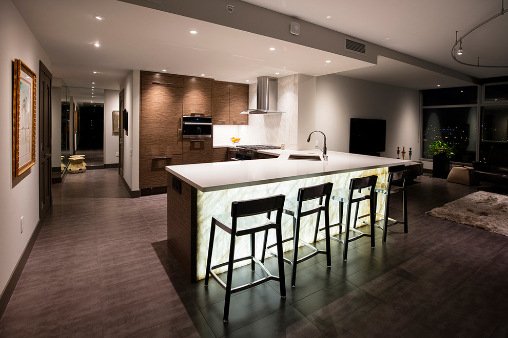 Photo of a mid-sized modern l-shaped open plan kitchen in San Diego with a single-bowl sink, flat-panel cabinets, brown cabinets, onyx benchtops, white splashback, stone slab splashback, panelled appliances, porcelain floors, with island and beige floor.