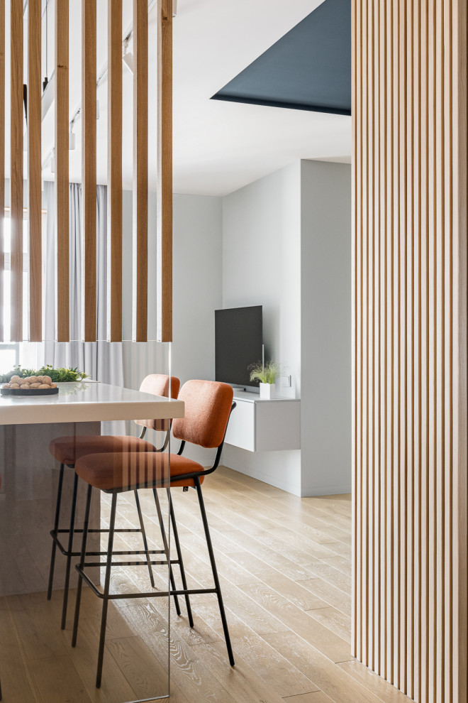 Immagine di una cucina design di medie dimensioni con top in superficie solida, pavimento in legno massello medio, pavimento beige e top bianco