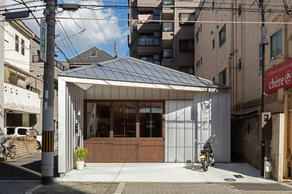 大阪にあるお手頃価格の小さなインダストリアルスタイルのおしゃれな玄関 (グレーの壁、濃色木目調のドア、グレーの床、折り上げ天井、パネル壁、白い天井) の写真
