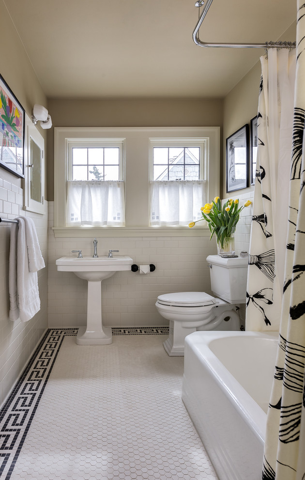 This is an example of a mid-sized traditional bathroom in Seattle with a corner tub, a shower/bathtub combo, a two-piece toilet, black and white tile, ceramic tile, beige walls, ceramic floors and a pedestal sink.