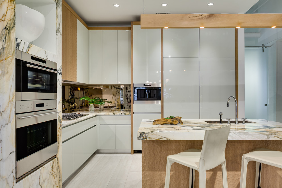This is an example of a large contemporary l-shaped separate kitchen in Miami with an undermount sink, flat-panel cabinets, white cabinets, mirror splashback, stainless steel appliances, porcelain floors, with island, white floor and multi-coloured benchtop.