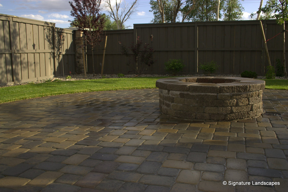 Mid-sized traditional backyard patio in Other with a fire feature and brick pavers.