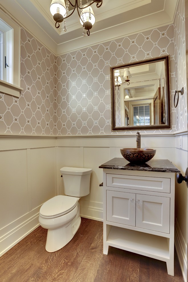 Design ideas for a mid-sized transitional powder room in Minneapolis with a vessel sink, recessed-panel cabinets, white cabinets, onyx benchtops, a two-piece toilet, grey walls and medium hardwood floors.