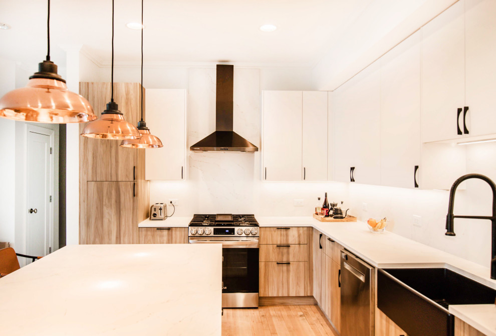 Contemporary l-shaped kitchen in Chicago with a farmhouse sink, flat-panel cabinets, light wood cabinets, white splashback, stainless steel appliances, light hardwood floors, with island and white benchtop.