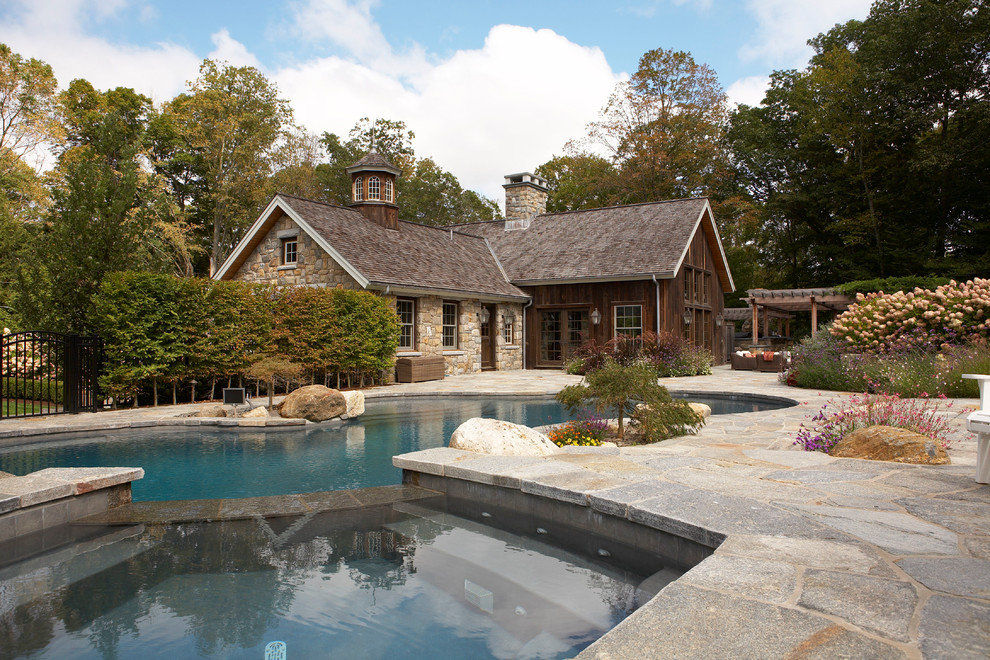 Country backyard custom-shaped pool in New York with natural stone pavers and a hot tub.