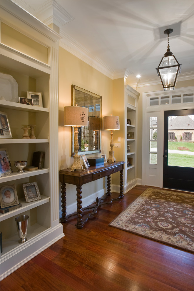 This is an example of a traditional foyer in Other with orange walls, medium hardwood floors, a single front door and a glass front door.