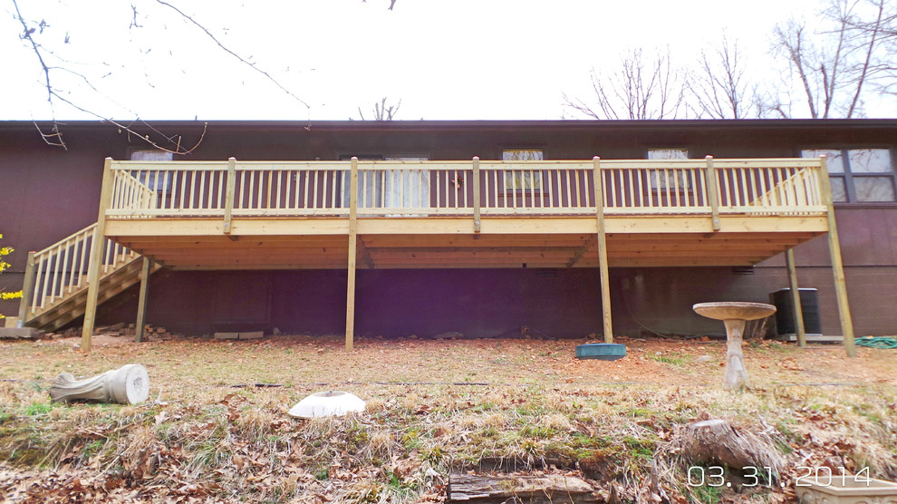 Example of a mid-sized backyard deck design with decking and no cover