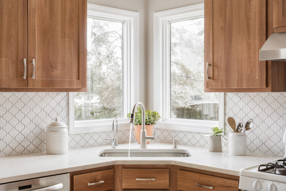 Example of a large transitional l-shaped cement tile floor and white floor eat-in kitchen design in Philadelphia with a single-bowl sink, flat-panel cabinets, medium tone wood cabinets, quartzite countertops, white backsplash, ceramic backsplash, stainless steel appliances, an island and white countertops