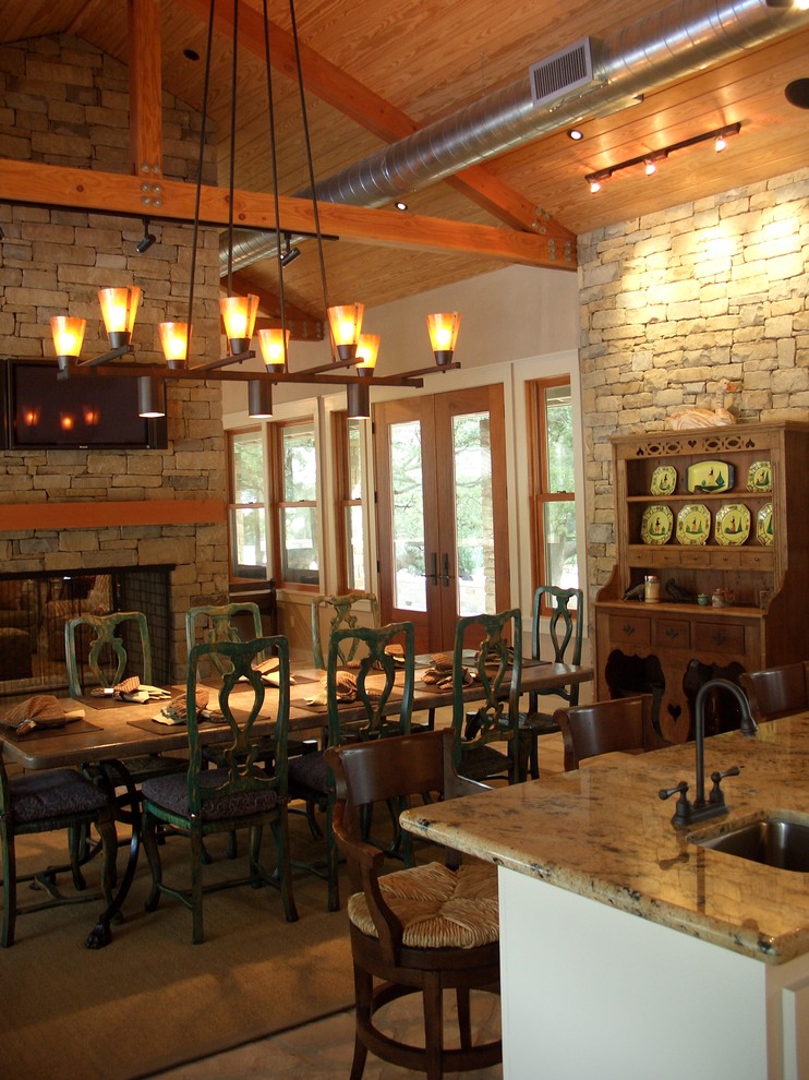 Inspiration for a country kitchen/dining combo in Houston with a two-sided fireplace and a stone fireplace surround.