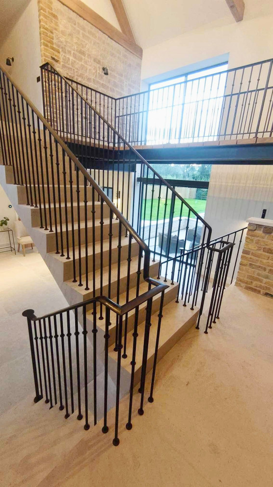 Diseño de escalera suspendida minimalista de tamaño medio con escalones de travertino, contrahuellas de travertino y barandilla de metal