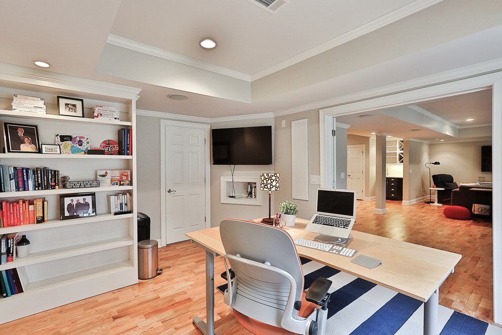 Photo of a mid-sized transitional study room in Atlanta with grey walls, light hardwood floors, no fireplace, a freestanding desk and beige floor.